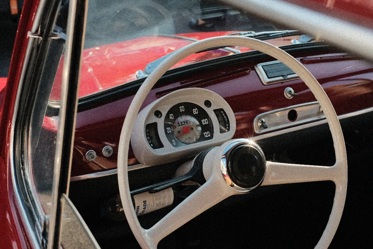 A photo of a steering wheel in a retro car.